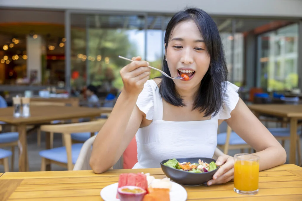 A woman eating a bowl of healthy food.