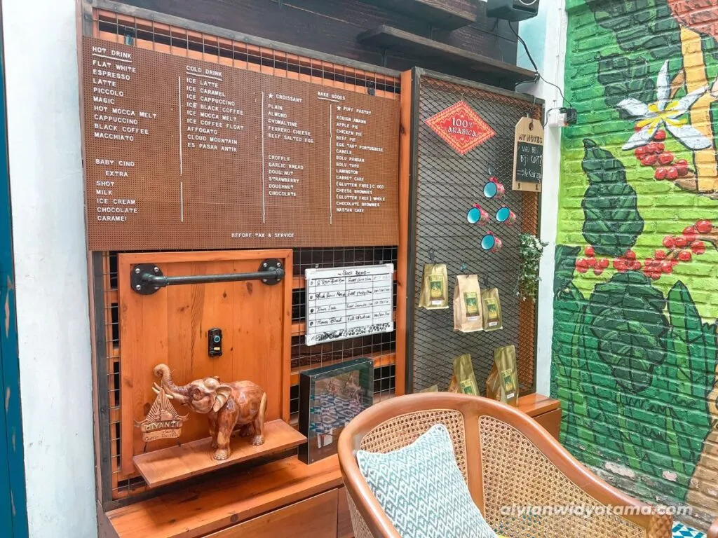 Giyanti Coffee Roastery, area indoor dan papan berisikan menu yang tersedia.